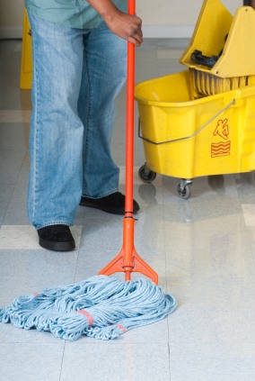 TUG Cleaning Services janitor in Utica, NY mopping floor.